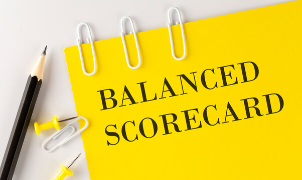 BALANCED SCORECARD word on the yellow paper with office tools on white background