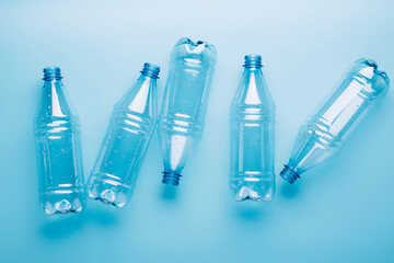 Empty plastic bottles on a blue background. Recycling recyclable plastic. Environment protection