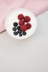 tasty raspberries and blueberries in a yogurt bowl