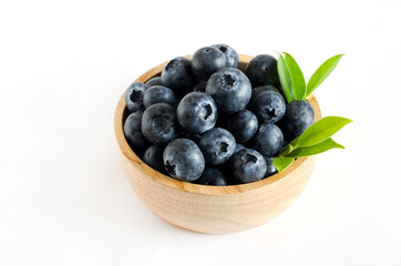 Closed up fres organic blue berry fruit in wooden bowl on white background