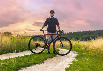 Cyclist standing with his gravel bicycle during outdoors sport training