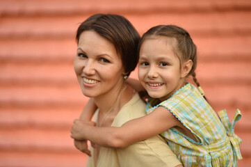 Portrait of happy mother and daughter posing outdoors