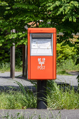 手紙を投函する赤い郵便ポスト