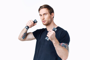 Naklejka premium sporty man in a black t-shirt with dumbbells in his hands on a white background