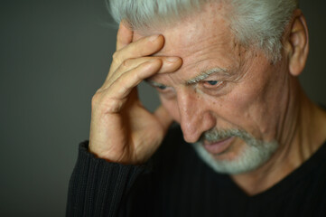 Fototapeta premium Portrait of sad senior man with headache
