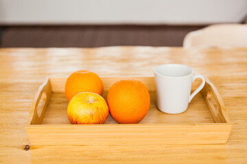 A tray with oranges and apples, fruits and vitamins for drinking, cooking