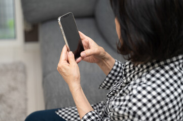 ワクチン予約で迷う日本人シニア(高齢女性) 
 コピースペースあり