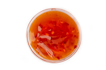 Hot pepper sauce or ketchup with seeds in a transparent bowl isolated on a white background. Top view.