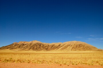 Fototapeta na wymiar Hills in the Namibian desert on a sunny day with blue sky and no clouds