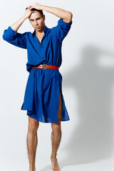 an attractive man in a blue dress and in a red one with a red belt on a light background 