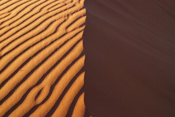Dune in the Namibian desert at sunset, one side is structured, the other plain, vertical spacing