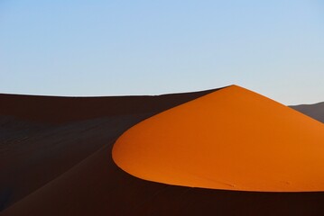 Fototapeta na wymiar Red dune at sunset in the Namibian desert at Sossusvlei Nature Reserve
