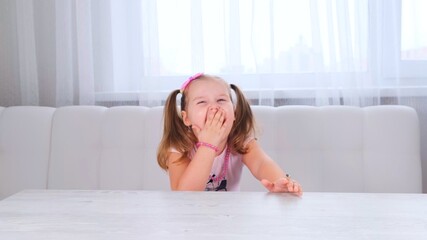 portrait of a pretty cute laughing girl 3-4 years old with big eyes and a beautiful hairstyle with a pink bow, laughing child, beads and other decorations.