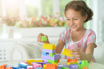 little girl playing with colorful plastic blocks