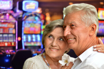  senior couple posing on blurred casino background