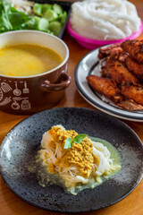 Rice noodles in fish curry sauce with fried chicken and fresh organic vegetable set.