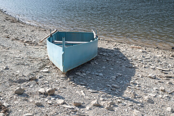 The boat left out of the lake by the retreat of the lake waters. The concept of drought and climate...