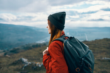 woman jacket hats looking at the mountain in the distance blue sky clouds Model backpack