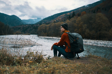 Fototapeta na wymiar woman travels in the mountains near the river in the meadow in the forest rest relax