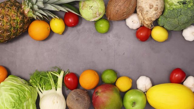 Fresh organic heathy fruits and vegetables appear on top and bottom of dark kitchen table. Stop motion 