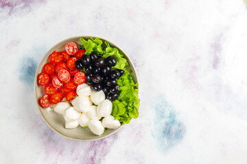 Salad with mozarella cheese, olives and cherry tomatoes.