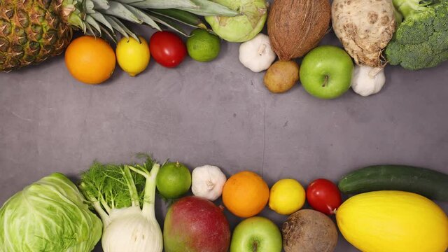 Fresh organic heathy fruits and vegetables ordering on top and bottom of dark kitchen table. Stop motion 