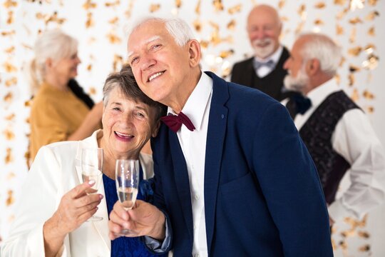 Cute elegant senior couple toasting with champagne during New Year's Eve