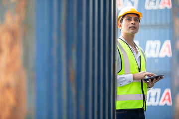 factory worker or engineer using tablet for preparing a job and looking something in containers warehouse storage