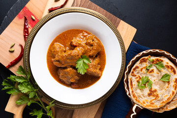 Food concept Homemade beef masala curry and roti paratha on wooden board with copy space