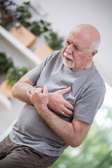 Senior grey man home alone having a heart attack