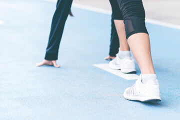 Close up selective focus Woman foot with sneaker on running track getting ready to start. exercise, fitness, workout, sport, lifestyle concept. Goal of business. Forward to Success concept.