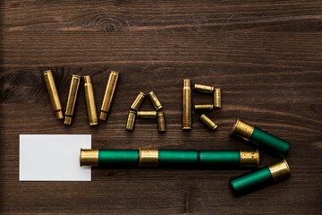 Shells and cartridges from the shotgun are in the form of arrows on an old wooden table. Shells form the word 