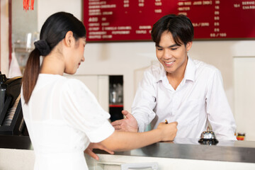 woman guest write signature for check in hotel from receptionist on clipboard