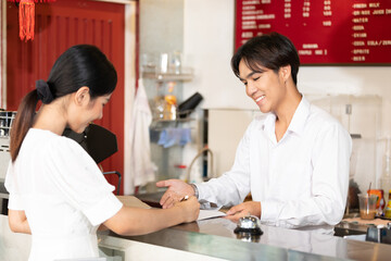 woman guest write signature for check in hotel from receptionist on paper