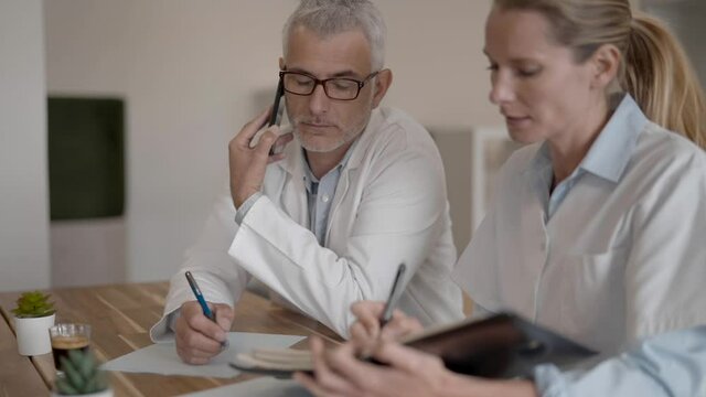 Doctors receiving call in meeting room