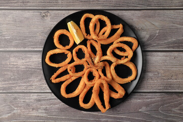 Ration of squid a la romana (Andalusian frying) on wooden table