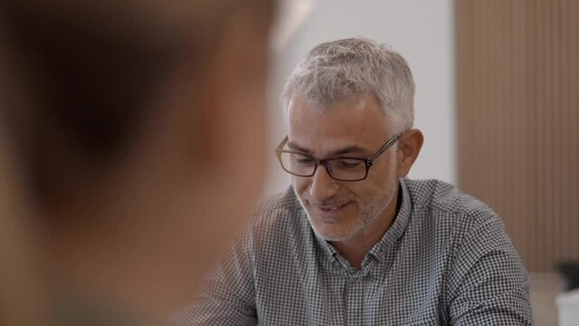 Closeup of businessman having conversation in office with work team