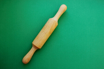 A rock for a test made of wood on a green background. Cooking and baking. cookery. View from above. Copy space. The scayth for the test is crushed on the left.