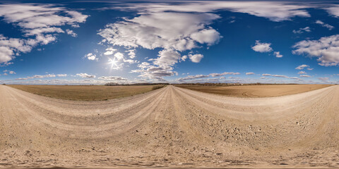 no traffic white sand gravel road among fields with cloudy sky in equirectangular projection, VR AR...
