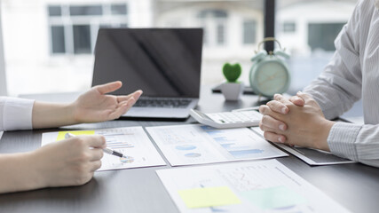 Brainstorm team, Marketers and financial accountants are discussing and analyzing charts to plan strategies to meet customer needs, Using graphs and laptops to analyze business data, Meeting concept.