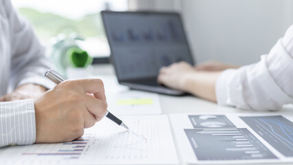 Brainstorm team, Marketers and financial accountants are discussing and analyzing charts to plan strategies to meet customer needs, Using graphs and laptops to analyze business data, Meeting concept.