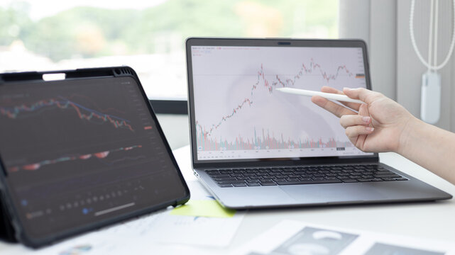 Investors sit and watch graphs of stock market data and watch the world market chart change, Investing in cryptocurrency in the stock market, Business people work on tablets and laptops.