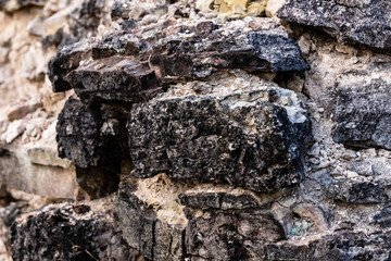 Close up view of black grey stonewall texture at Vecdole castle in Latvia built 1226 . Surface of rocks. Old vintage rock structure.  Abstract background of granite brick construction