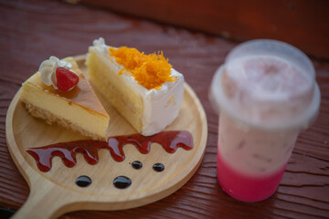 Iced coffee in plastic cups with cakes placed on the table in a cozy cafe corner.