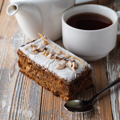 Close up of rich aroma nut pie, thickly covered with powdered sugar, wooden flat background