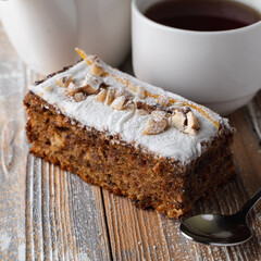Close up of rich aroma nut pie, thickly covered with powdered sugar, wooden flat background