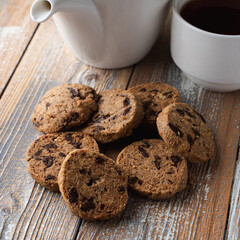 A pile of chocolate chip cookies on a wooden rustic table