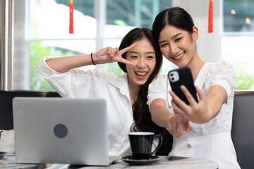 young couple woman taking photo or selfie together from smartphone and showing victory sign post in free time