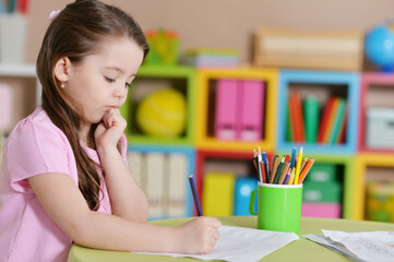 Cute little girl in pink shirt drawing