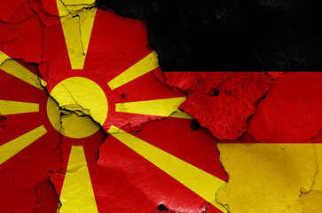 flags of North Macedonia and Germany painted on cracked wall